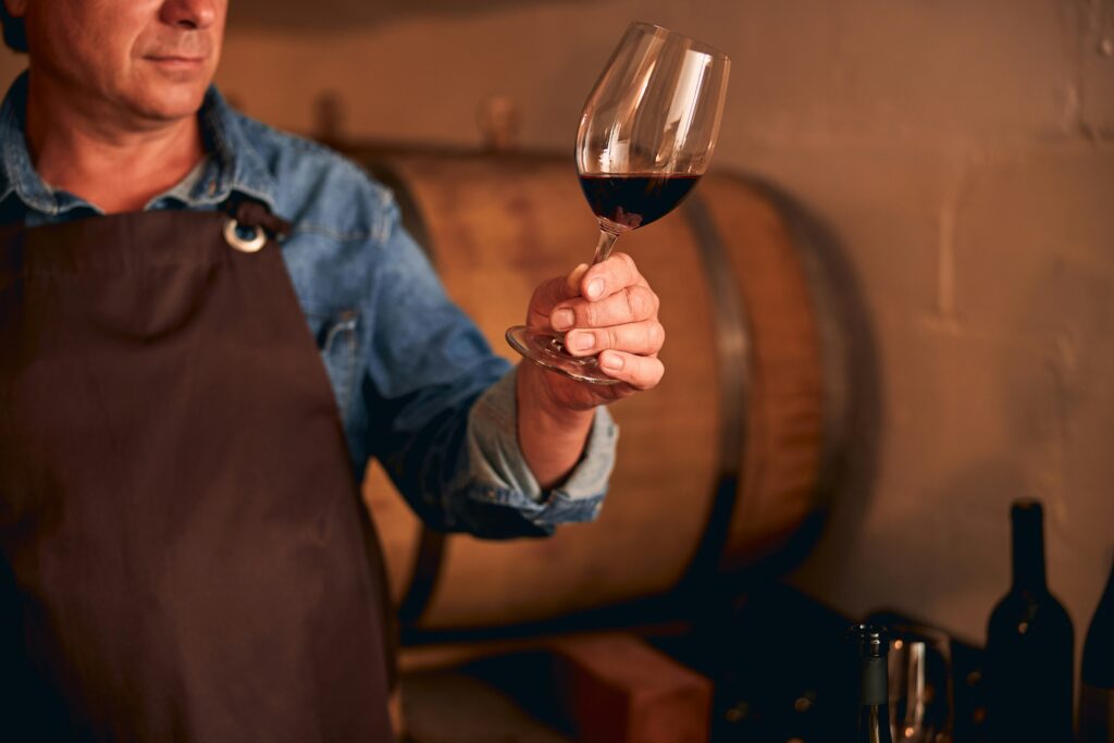 A high-action pour of rich red Caymus wine into a crystal glass, showcasing the deep hue typical of luxury napa wines.